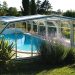 Abri de piscine haut Abritech dans un décor verdoyant